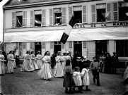 Procession ou fête historique. Passage d'une groupe de jeunes filles costumées devant l'Hôtel de la Marine