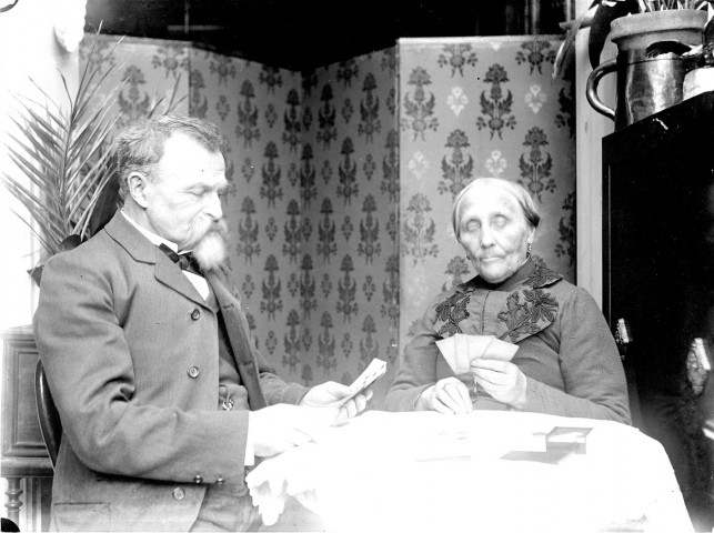 Scène de la vie quotidienne d'une famille bourgeoise. Un homme et une femme âgés jouant aux cartes