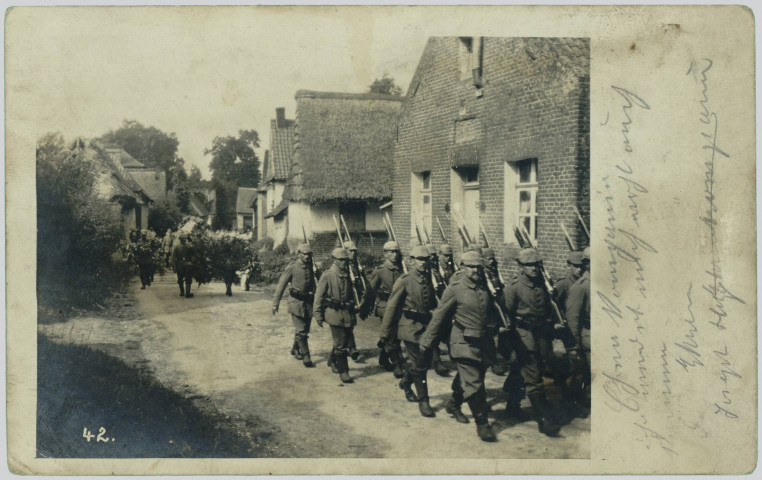 CARTE-PHOTO MONTRANT DES SOLDATS ALLEMANDS MARCHANT AU PAS DANS UNE RUE