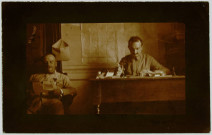 CARTE-PHOTO MONTRANT, DANS UN BUREAU, UN OFFICIER ASSIS LISANT ET UN HOMME A SON BUREAU. SEPIA. MARCELLE TINAYRE (1870-1948). ECRIVAIN