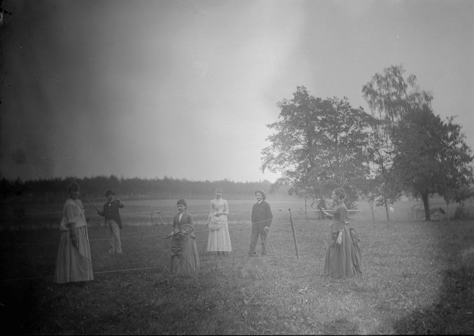Portrait de famille de M Durand, des gens jouant au tennis dans une prairie
