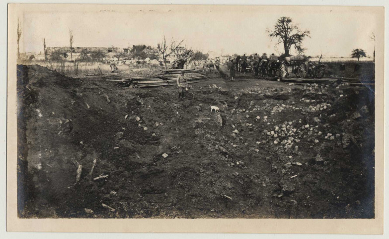 Passage de troupes près d'un trou d'obus à Roye