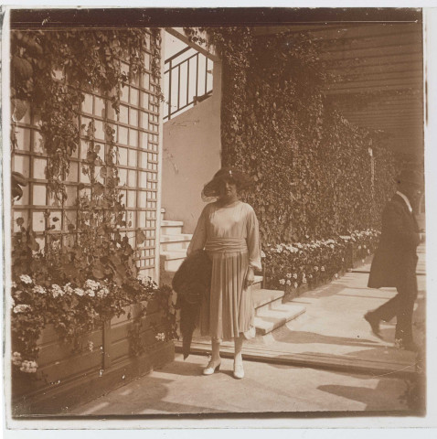 Femme posant près de plantes grimpantes