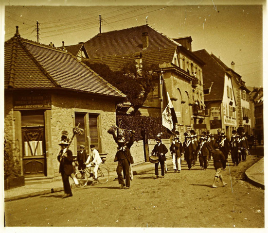 Kermesse dans les rue de Saint-Hippolyte (?) : fanfare portant une bannière "St Hippolyte"