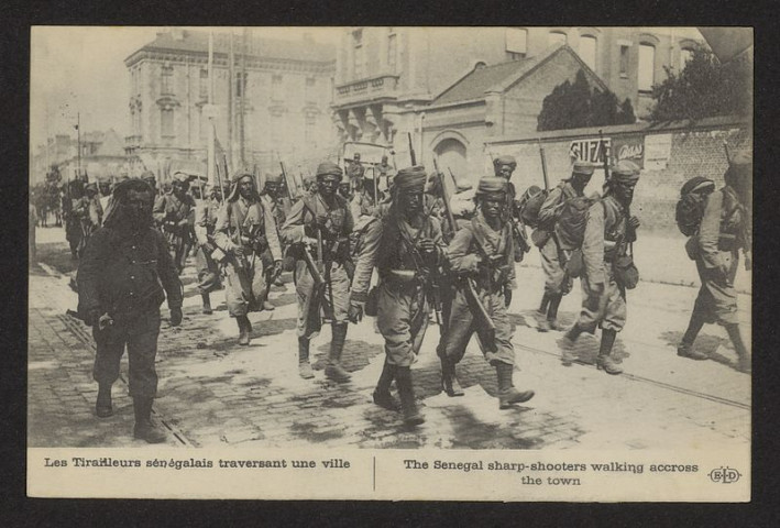 LES TIRAILLEURS SENEGALAIS TRAVERSANT UNE VILLE. THE SENEGAL SHARP-SHOOTERS WALKING ACCROSS THE TOWN