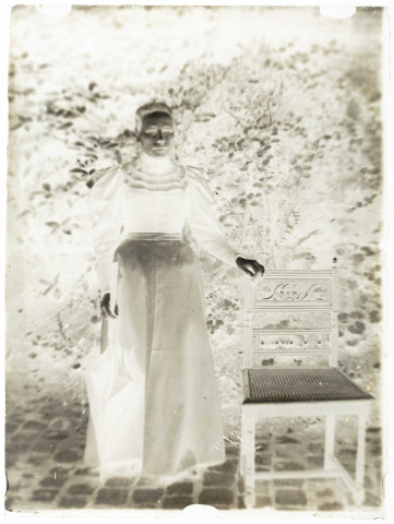 Martinsart (Somme). Portrait d'une femme avec un parapluie, posant près d'une chaise dans une cour ou un jardin