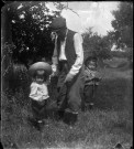 Un homme et deux enfants sur un chemin de campagne