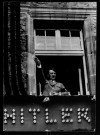 Adolf Hitler faisant le salut nazi depuis une fenêtre