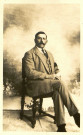 Portrait de Georges Delignières assis, portant un brassard noir au bras gauche