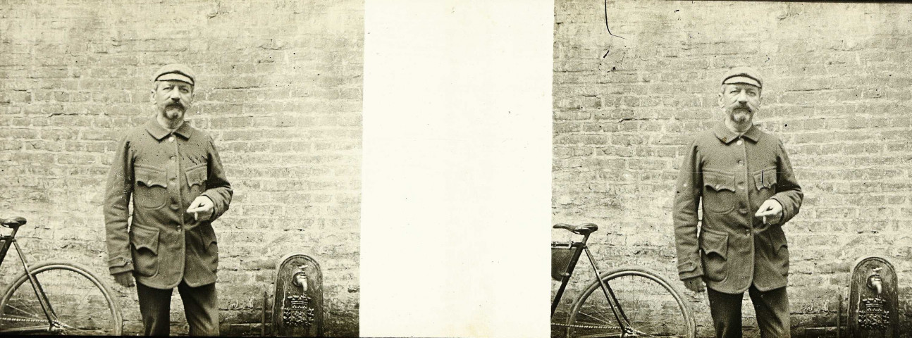 Un homme fumant une cigarette. Au second plan, une bicyclette et un robinet fontaine comportant des armoiries
