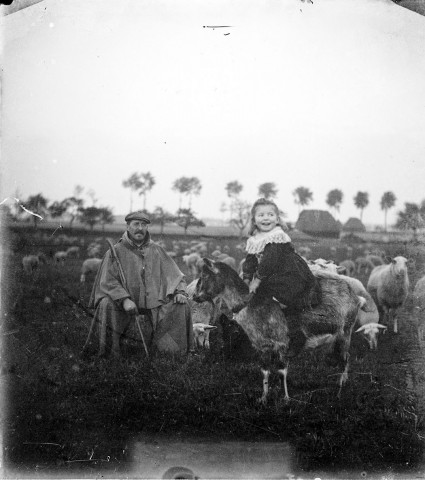 Un troupeau de moutons et son berger, portrait d'une enfant sur un mouton