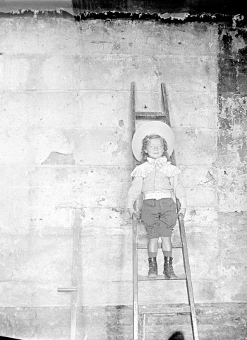 Portrait d'enfant posant sur une échelle