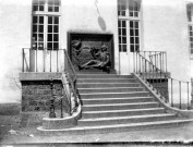Plaque en fonte figurant une scène militaire située en haut de l'escalier d'une belle demeure