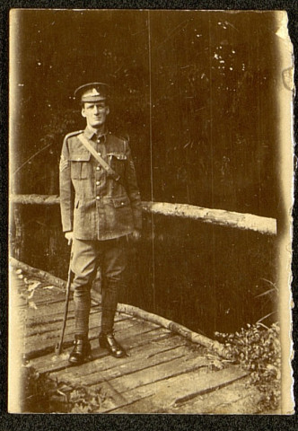 Portrait d'un soldat britannique en convalescence posant sur un pont de bois appuyé sur sa canne