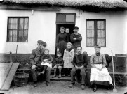 Portrait de groupe d'une famille d'ouvriers devant le seuil de la maison