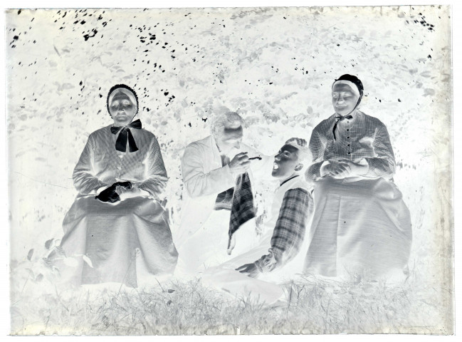 Scène de la vie quotidienne d'une famille bourgeoise. Deux femmes âgées et deux hommes se mettant en scène dans un jardin