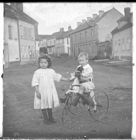 Enfants jouant avec un tricycle avec une forme de cheval