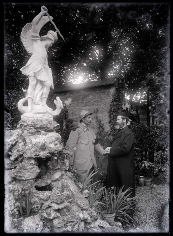 Soldat serrant la main d'un prêtre au pied d'une statue