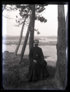 Portrait d'un prêtre assis sous des arbres en bord de mer