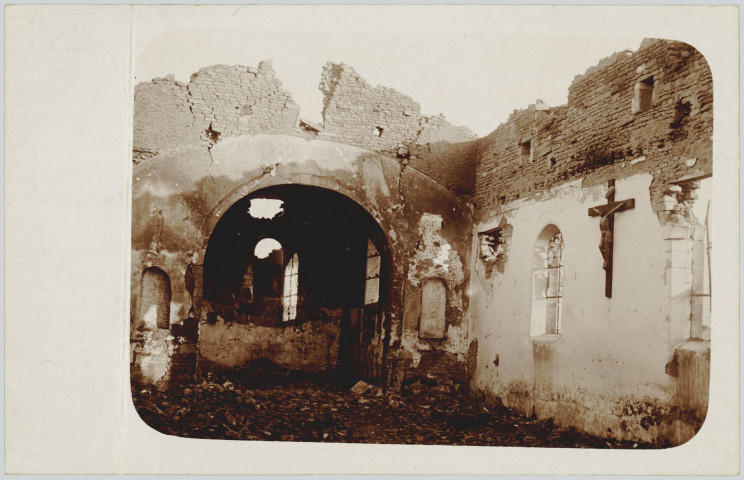 CARTE-PHOTO MONTRANT L'INTERIEUR D'UNE EGLISE EN RUINE (SANS TOIT). UN CHRIST EST ENCORE ACCROCHE SUR LE MUR, COTE DROIT DE LA PHOTOGRAPHIE. MANUSCRITE AU CRAYON AU DOS. PLIURE MARQUEE BORD GAUCHE