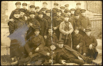 Groupe de 28 soldats en uniformes portant une casquette