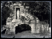Statue de la Vierge nichée dans les ruines d'un bâtiment envahi par la végétation
