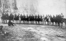 Une troupe de militaires à cheval devant la falaise