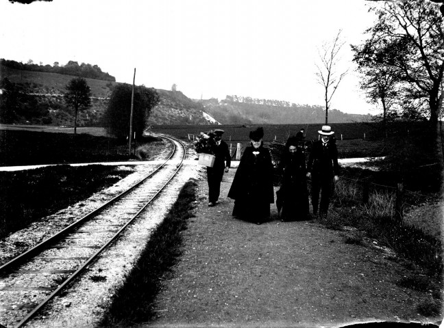 Personnages marchant le long de la voie ferrée