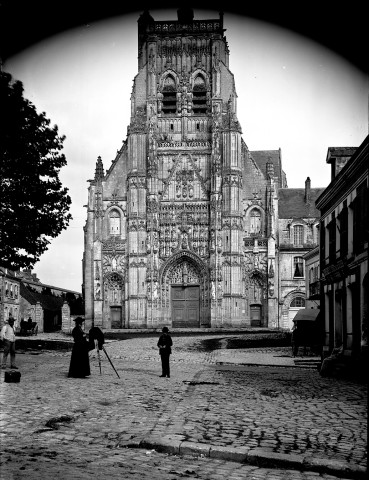 Saint-Riquier (Somme). L'église abbatiale : un prêtre installe son appareil photographique sur un trépied devant l'église