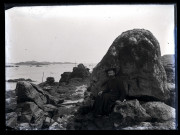 Portrait d'un prêtre assis sur des rochers en bord de mer