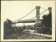 Soldats du 70e Régiment d'Infanterie, dont Gustave Lecomte, au pied d'une tour en pierre crênelée d'un pont suspendu de chemin de fer en partie détruit
