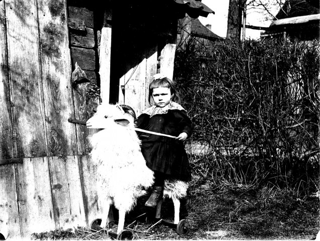 Portrait de fillette jouant avec un mouton mécanique