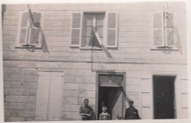 Libération de Molliens-Vidame. Une maison de Molliens parée de drapeau. Les habitants sur le seuil de la porte regarde le passage des troupes anglaises