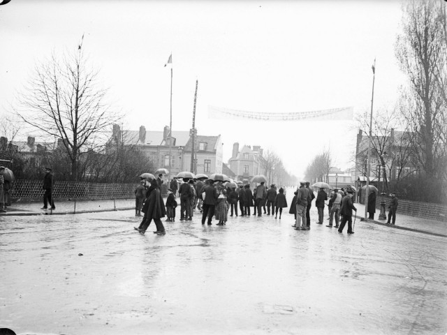Amiens. Avenue Foy sous la pluie. Les spectateurs sous la banderole du PARIS-ROUBAIX, en 1902. Cette 7e édition de la course cycliste Paris-Roubaix fut remportée par le français Lucien Lesna
