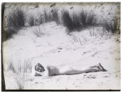 [Une jeune femme nue allongée dans le sable]