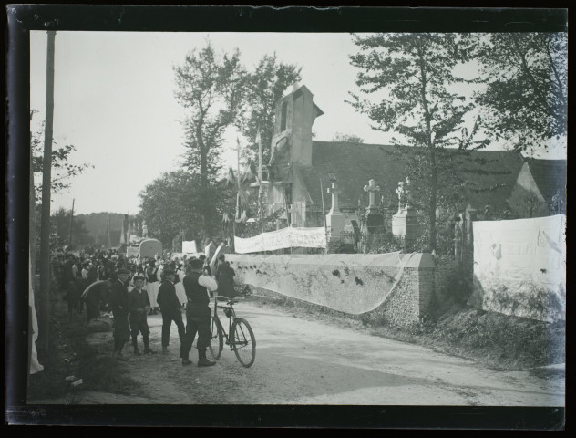 [Fête de Jeanne d'Arc à Camiers - octobre 1909. Attroupement près de l'église de Camiers (rue menant à Etaples-sur-Mer). Une banderole est posée à l'entrée du cimetière près de l'église et porte la mention "A Jeanne d'Arc"]