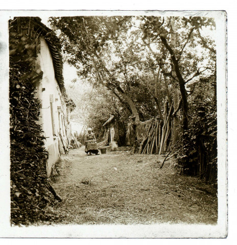 Fontaine-sur-Somme. Une vieille femme assise devant sa maison