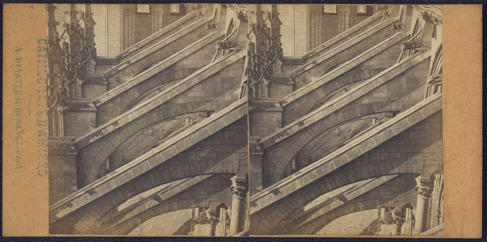 La cathédrale d'Amiens. Arcs-boutants du flanc sud de la nef, avec la tour en arrière plan. On distingue deux ouvriers sous un arc-boutant