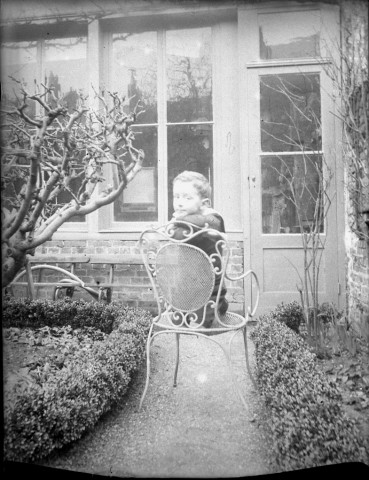 Amiens. Un enfant sur une chaise de jardin