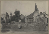Une jeune fille (Lucille Pilette ?) posant devant les ruines d'une maison