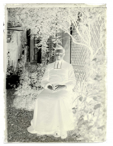 Portrait d'un prêtre assis dans un jardin