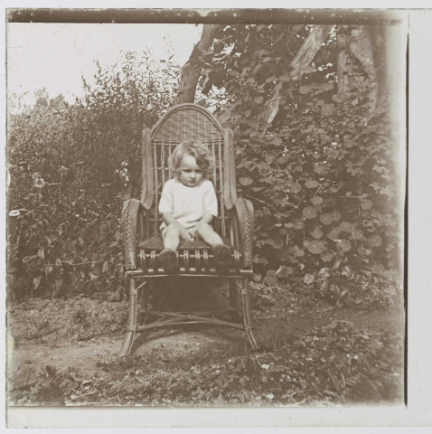 Enfant dans un fauteuil en osier