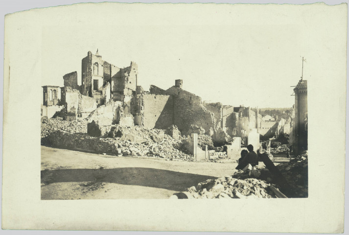 PHOTOGRAPHIE MONTRANT DES RUINES. DEUX PERSONNES AU PREMIER PLAN A DROITE