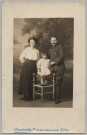 CARTE PHOTO PRISE EN STUDIO MONTRANT UNE FAMILLE. LE PERE EST EN UNIFORME (INFANTERIE) AVEC LA CROIX DE GUERRE. LA FEMME EN ROBE NOIRE ET CHEMISE BLANCHE. L'ENFANT EN ROBE BLANCHE, SOULIERS VERNIS ET UN NOEUD DANS LES CHEVEUX
