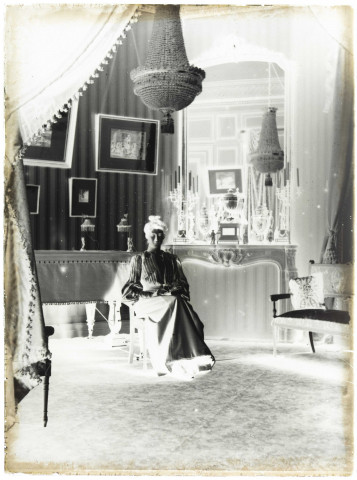 Environs de Lille (Nord). Intérieur d'une maison bourgeoise. Famille Danel. Portrait d'une femme assise devant une cheminée richement sculptée