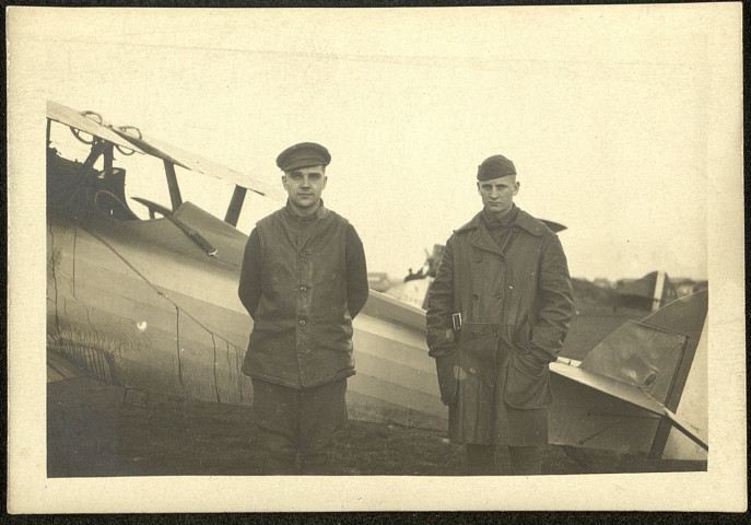 Deux aviateurs près de leur appareil sur un terrain d'aviation non identifié