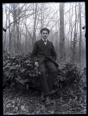 Un homme assis dans un sous bois