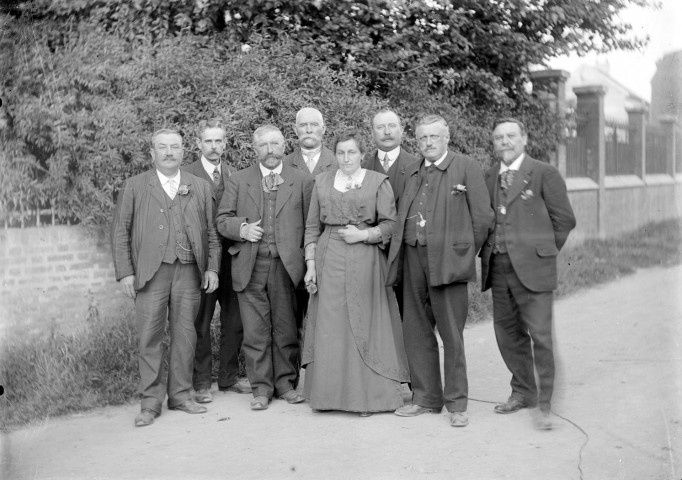 Portrait d'un groupe d'hommes entourant une femme