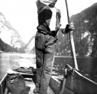 Un homme dans sa barque sur un lac en montagne