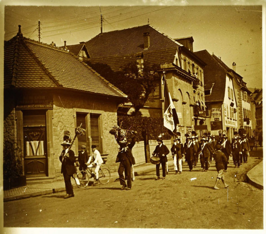 Kermesse dans les rue de Saint-Hippolyte (?) : fanfare portant une bannière "St Hippolyte"